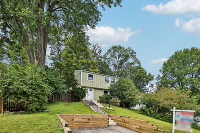 Spacious split-level home surrounded by mature trees, featuring ample outdoor space and convenient access to amenities.