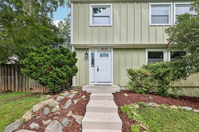 Modern two-story home featuring a welcoming entrance and landscaped yard, perfect for outdoor enjoyment.