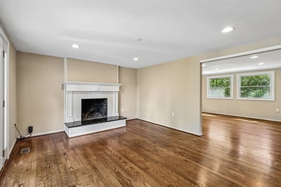 Spacious living area featuring a classic fireplace and large windows, creating a bright and inviting atmosphere.