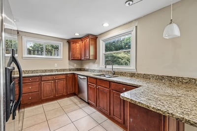 Spacious kitchen featuring rich wood cabinetry, granite countertops, and ample natural light for a warm atmosphere.