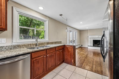Bright kitchen with ample counter space, flowing into a cozy living area with a fireplace.