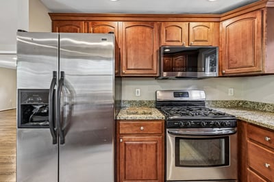 Modern kitchen featuring stainless steel appliances, ample cabinetry, and granite countertops, perfect for culinary enthusiasts.