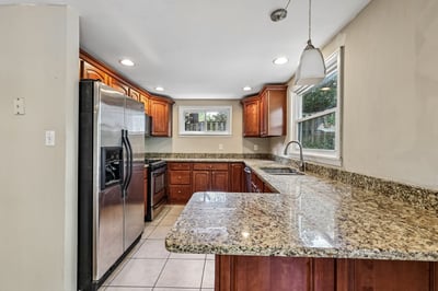 Discover this spacious kitchen featuring ample storage, modern appliances, and inviting granite countertops for culinary enthusiasts.