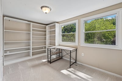 Bright and airy room with built-in shelves and ample natural light, perfect for a home office or study.