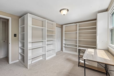 Versatile room featuring built-in shelving, ideal for a home office or creative workspace.