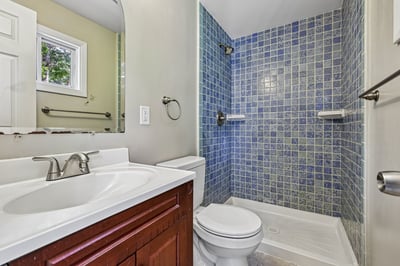 Modern bathroom featuring vibrant tile accents and functional layout for everyday convenience. Ideal for your home!