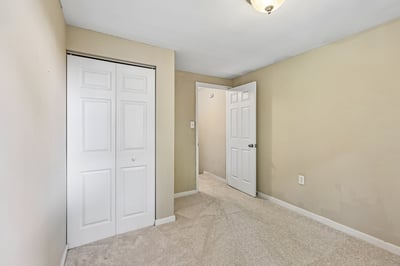 Spacious bedroom featuring ample closet space and fresh carpeting, perfect for personalized decor and comfort.