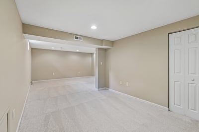 Spacious, versatile basement area ready for customization, featuring neutral tones and ample natural light.