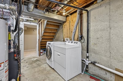 Spacious laundry area in the basement features modern appliances and ample storage for convenience.