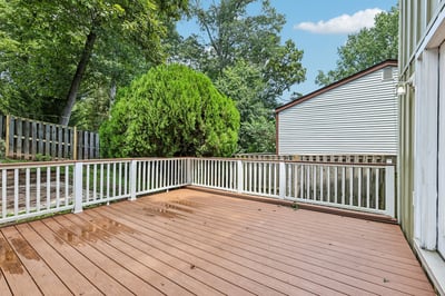Spacious outdoor deck surrounded by lush greenery, perfect for entertaining or relaxing in your private retreat.