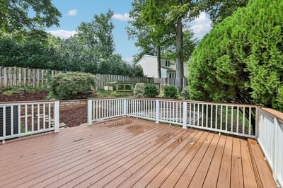Spacious outdoor deck surrounded by lush greenery, perfect for hosting gatherings or enjoying quiet moments.