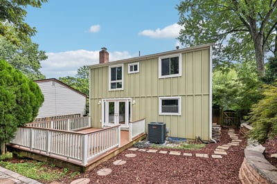 This inviting two-story home features a spacious deck and landscaped yard, perfect for outdoor gatherings.