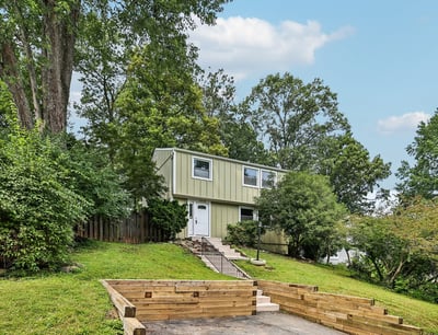 This unique split-level home offers spacious living areas surrounded by lush greenery and a private yard.