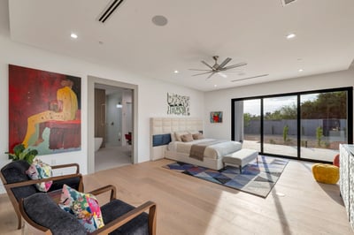 Light-filled primary suite with expansive windows, wood flooring, and direct access to outdoor living. This Paradise Valley home emphasizes indoor-outdoor lifestyle and modern comfort.