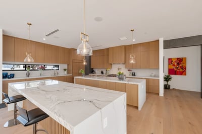 Modern chef s kitchen with two oversized islands, sleek cabinetry, and premium appliances. This Paradise Valley home offers functional design and high-end finishes ideal for gatherings.