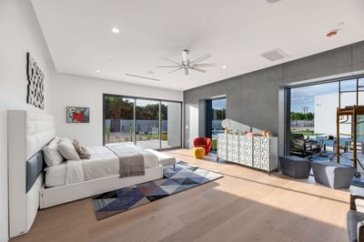 Elegant primary bedroom featuring large glass sliders, natural light, and seamless connection to outdoor living spaces. This Paradise Valley retreat blends comfort with modern design.