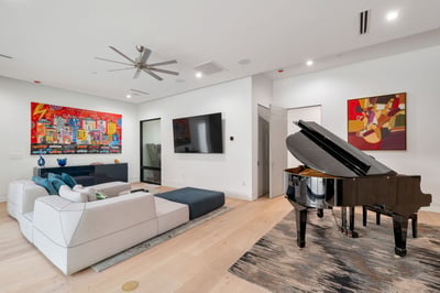 Open living room with modern furnishings, wood flooring, and built-in entertainment wall. This Paradise Valley home offers a blend of style, comfort, and functional living space.