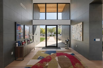 Dramatic entry with tall ceilings, glass doors, and modern architectural lines. This Paradise Valley home creates a welcoming yet sophisticated first impression.