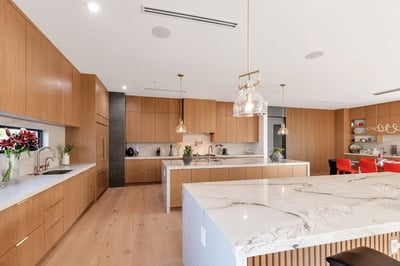 Contemporary kitchen featuring two oversized islands, quartz countertops, and custom cabinetry. This Paradise Valley residence offers high-end finishes and an entertainer-friendly layout.