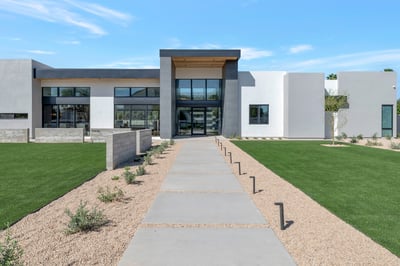 Detailed view of the home s contemporary exterior with clean lines and large glass windows. This Paradise Valley property emphasizes modern architecture and upscale design.