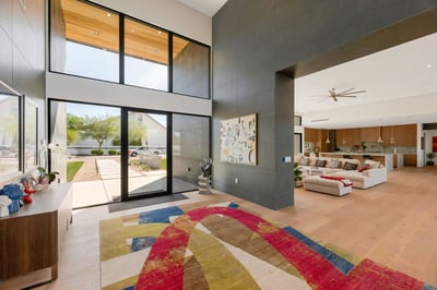 Grand entryway with tall glass doors and sleek architectural details. This Paradise Valley home creates a bold and elegant first impression.