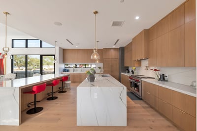Sleek kitchen featuring a large island, quartz countertops, and custom cabinetry. This Paradise Valley home is designed for entertaining with premium appliances and open flow.