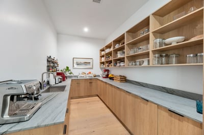 Functional pantry with open shelving, prep counter, and ample storage. This Paradise Valley home is designed for efficiency and modern living.