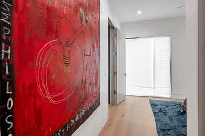 Interior hallway featuring clean architecture, wood floors, and bold artwork. This Paradise Valley home emphasizes modern design and open flow.