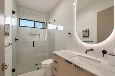 Bathroom with sleek vanity, glass shower, and contemporary lighting. This Paradise Valley home showcases updated fixtures and modern style.