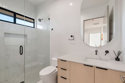 Modern full bathroom with glass shower, vanity storage, and sleek finishes. This Paradise Valley home offers upgraded bathrooms throughout.