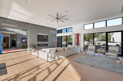 Open great room with tall ceilings, expansive windows, and modern fireplace wall. This Paradise Valley home offers a bright and airy living space.
