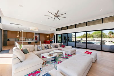 Bright open living space with full wall of glass showcasing the backyard and pool. This Paradise Valley home offers a perfect blend of comfort and luxury.