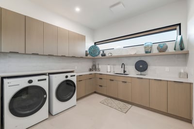 Stylish utility room with custom cabinetry, sleek countertops, and built-in sink. This Paradise Valley home offers a well-appointed laundry space with modern upgrades and efficient layout.