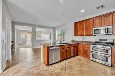 Stylish kitchen featuring granite countertops, stainless steel appliances, and rich wood cabinetry, offering both function and visual appeal.