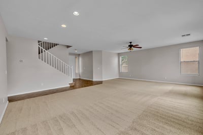 Open living room with fresh carpet, neutral finishes, and plenty of natural light, perfect for relaxing or hosting guests.