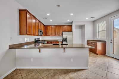 Bright dining space connected to the kitchen, featuring tile flooring and a layout perfect for hosting family meals.
