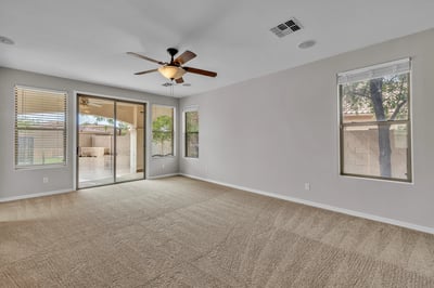 Comfortable living room with large windows and soft carpeting, creating a bright and airy space for relaxation.