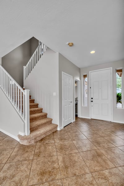 Inviting entryway with tile flooring and staircase access, creating a practical transition into the home's main living areas.