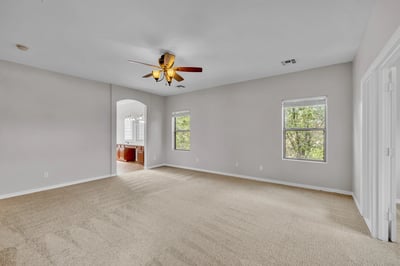 Cozy bedroom with neutral finishes and large windows, ideal for guests, family, or a home office.