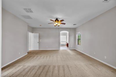 Inviting bedroom space featuring plush carpet, ceiling fan, and natural light for everyday comfort.