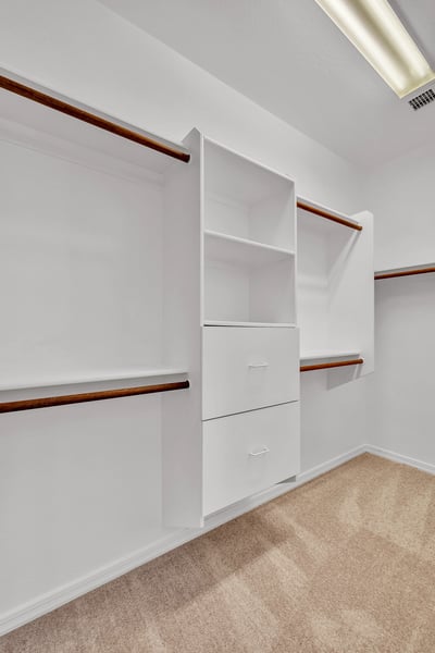 Well-designed walk-in closet with built-in shelving and hanging areas, providing organized storage within the primary suite.