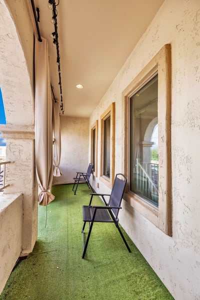 Private covered balcony with seating area, perfect for relaxing outdoors and enjoying the Arizona climate.