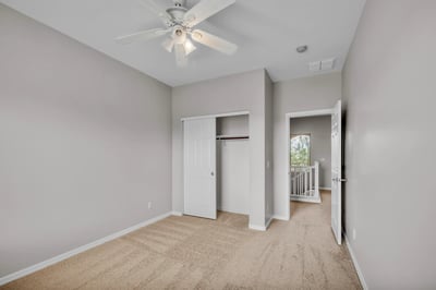 Functional bedroom featuring a closet for storage, neutral finishes, and ceiling fan, offering flexibility for various living needs in Goodyear.