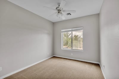 Inviting bedroom filled with natural light, complete with ceiling fan and carpet flooring, perfect for relaxing or guest accommodations in Goodyear.