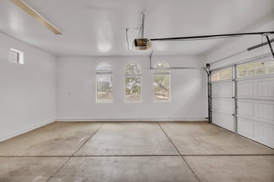 Clean and open two-car garage with high ceilings and extra storage potential, ideal for vehicles and equipment in Goodyear.
