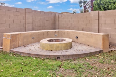 Backyard gathering space with built-in fire pit and surrounding seating, perfect for entertaining and enjoying outdoor living in Goodyear.