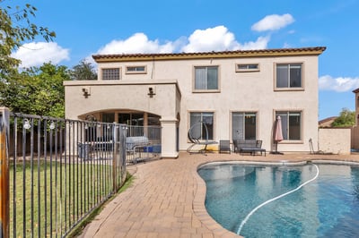 Expansive backyard in Goodyear featuring a private pool, covered patio, and seating areas, ideal for outdoor relaxation and entertaining.
