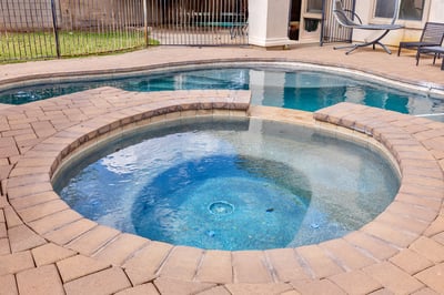 Detailed view of the spa with paver surround, showcasing a relaxing outdoor feature that enhances this Goodyear home's backyard.