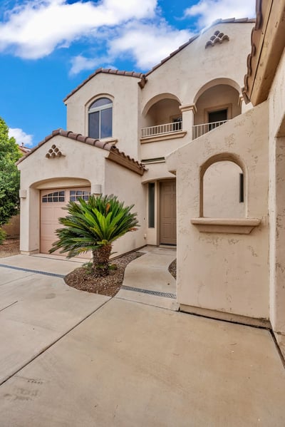 Front entry with classic arched details and landscaped surroundings, creating a welcoming first impression in this Goodyear home.