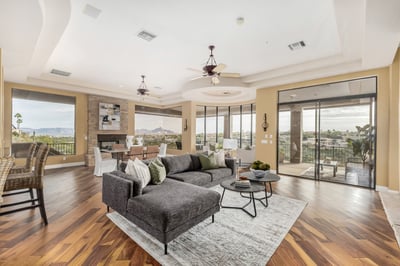 Bright and spacious living area designed to maximize natural light and showcase sweeping mountain vistas. Large windows, warm wood flooring, and an open layout create an inviting atmosphere for entertaining and everyday living.